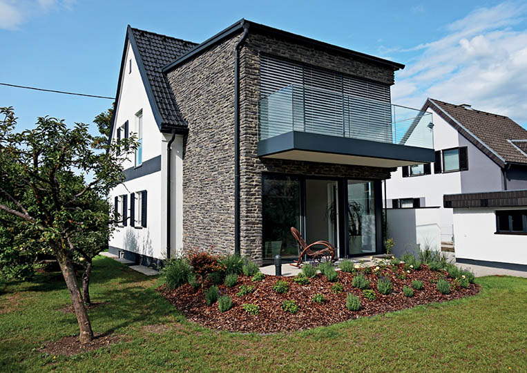Maison avec une extension construite en pierre reconstituée rastone sierra gris