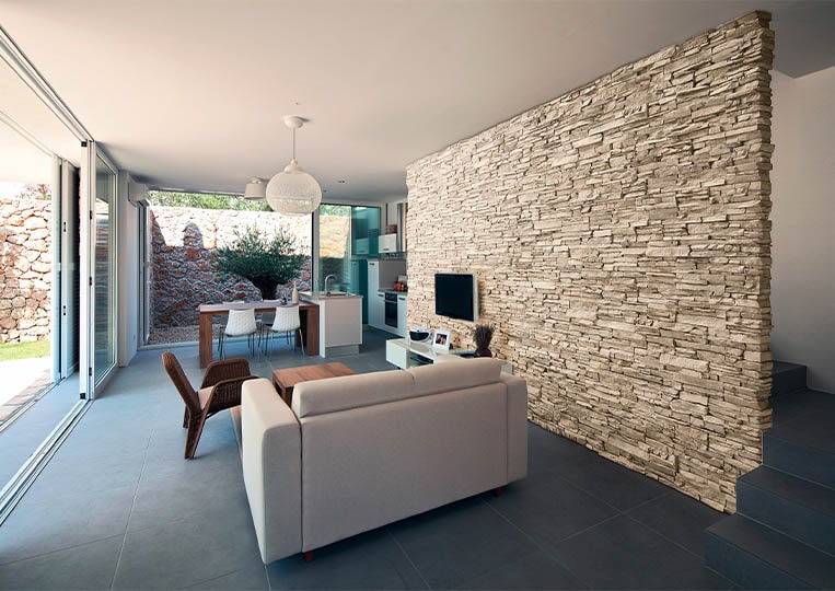 salon intérieur avec un pant de mur en pierre de parement acl siena sable clair