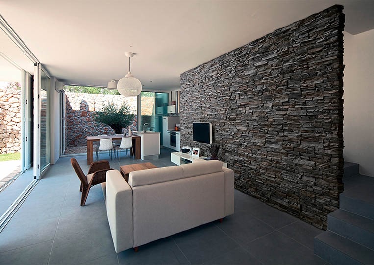 salon intérieur avec un pant de mur en pierre de parement acl siena anthracite
