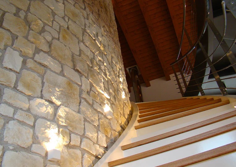 Mur construit en pierre reconstituée couleur sable adossé à un escalier