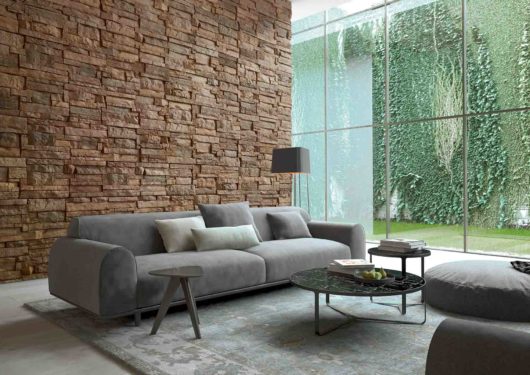 Salon intérieur avec un pan de mur en pierre reconstituée acl nisa