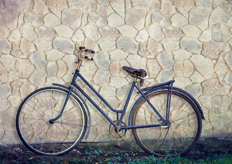Vélo posé sur un mur en pierre reconstituée mathios fieldstone clair